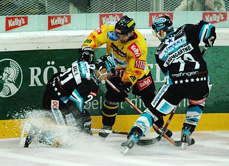 #21 Philipp Lukas, Kapitaen, und #79 Gregor Baumgartner, beide EHC Liwest Black Wings Linz kaempen um  die Scheibe.