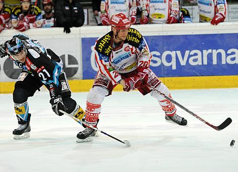 #21 Philipp Lukas, Stuermer, Liwest Black Wings Linz im Duell mit der #20 Mike Craig, KAC.