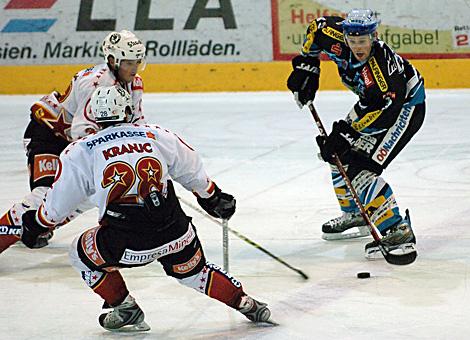#79 Gregor Baumgartner, Stuermer, EHC Liwest Black Wings Linz im Duell mit der #28 Ales Kranjc, Verteidiger, HK Acroni Jesenice.