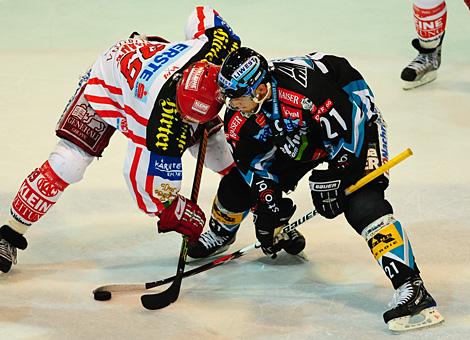 #21 Philipp Lukas, Stuermer, EHC Liwest Black Wings Linz beim Bully mit der #39 Jeff Shantz, KAC.